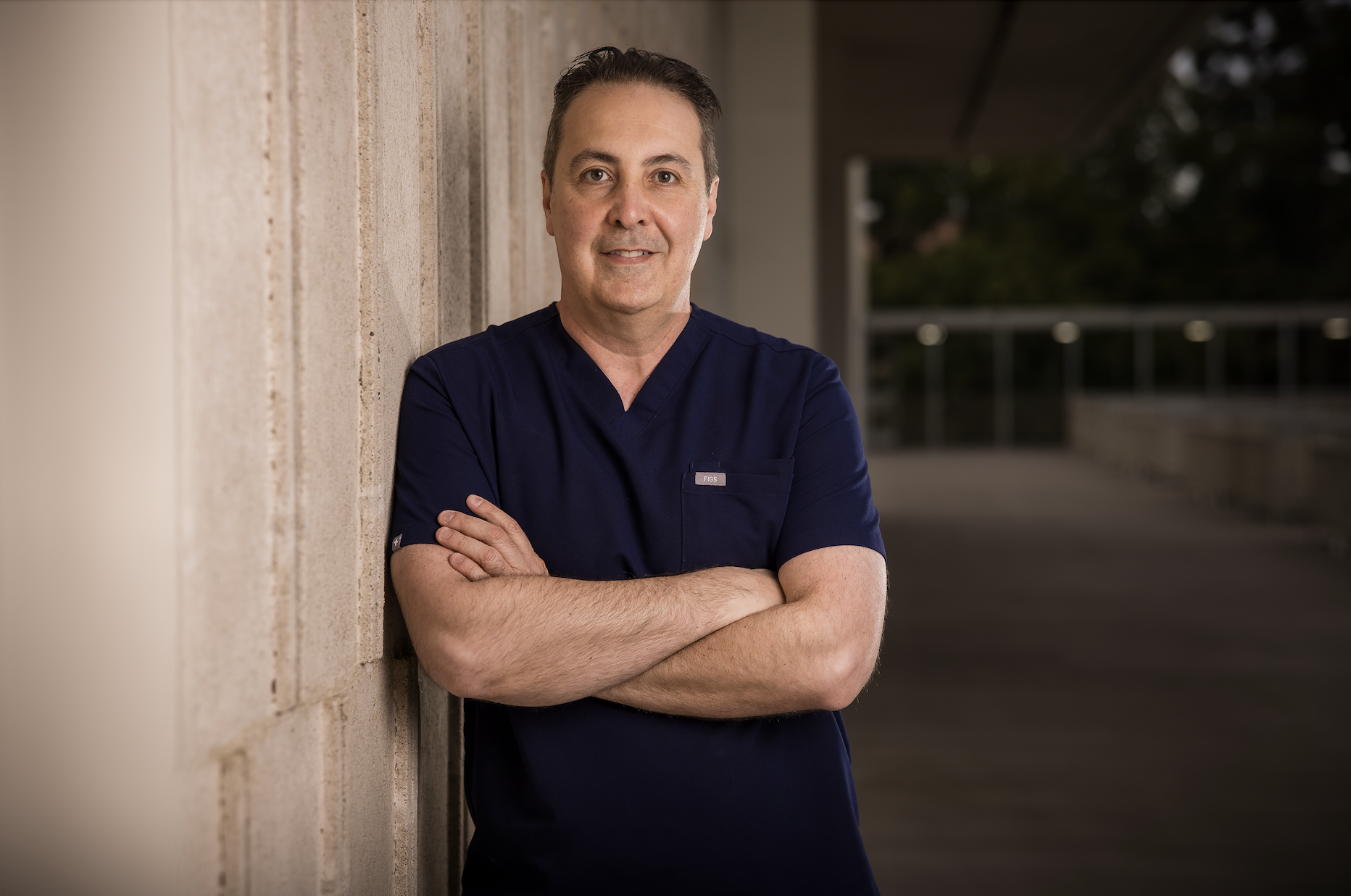 Dr. Raffy Karamanoukian MD FACS — UCLA-trained dual board-certified plastic surgeon specializing in emergency stitch removal and scar minimization at Kare Plastic Surgery Santa Monica Los Angeles — arms crossed, navy scrubs, FIGS badge